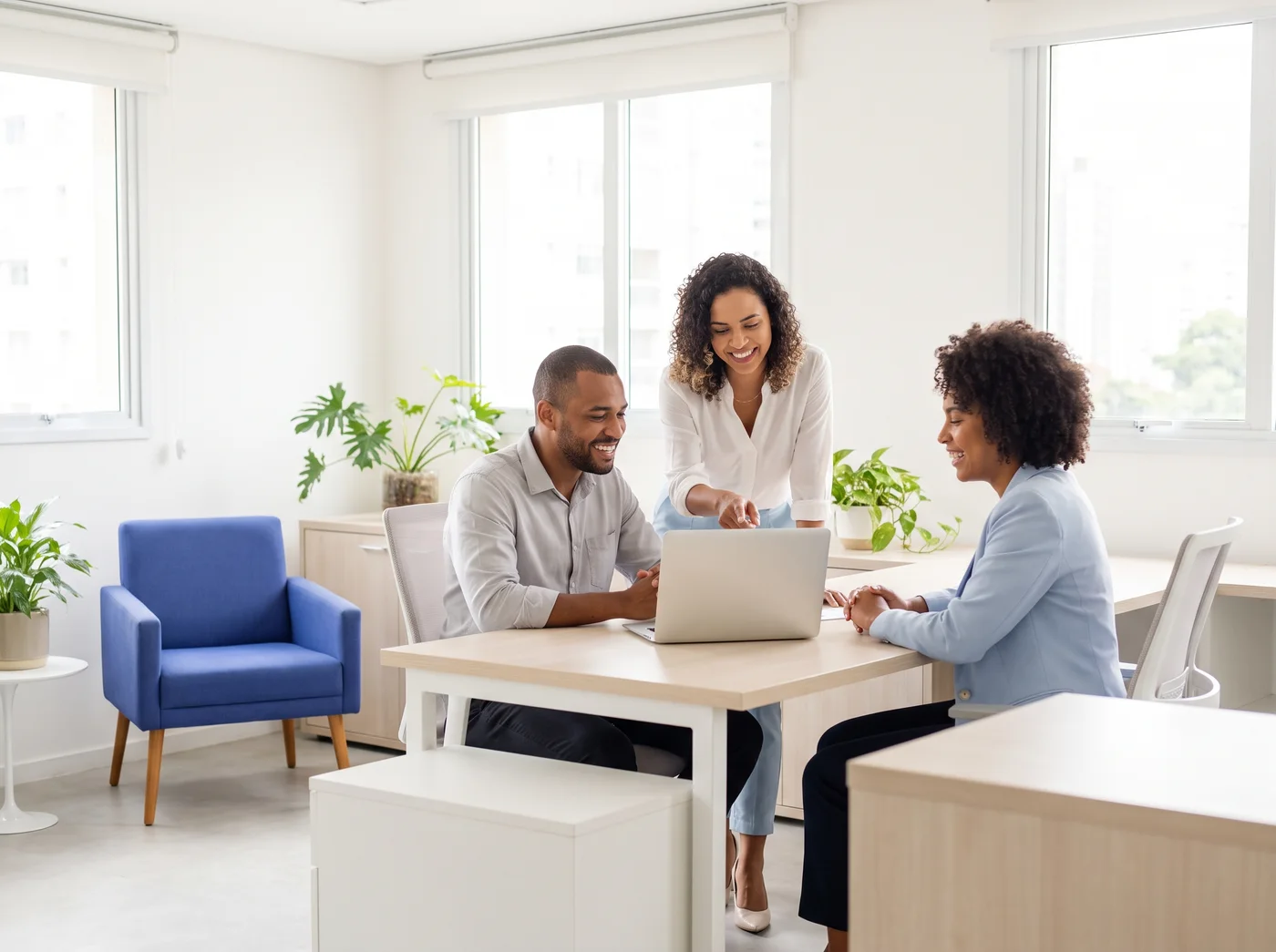 Equipe de imobiliária reunida em volta de um notebook
